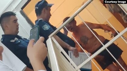 Сотрудники полиции и неизвестный мужчина у двери квартиры Баян Ширынбековой